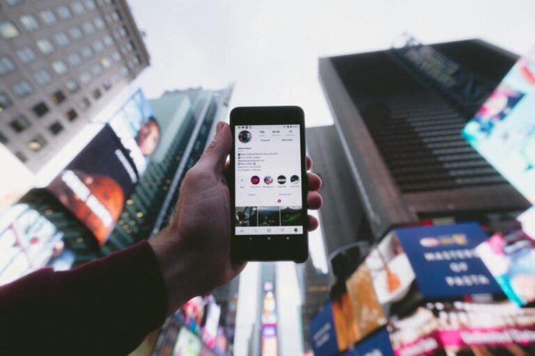 search engine optimization services image of a person surrounded by skyscrapers showing their smartphone's screen