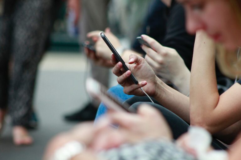 A line of people all holding Smartphones