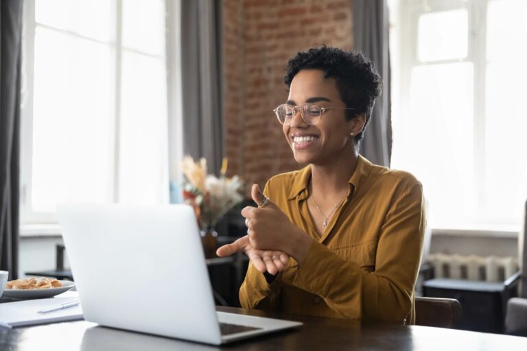 woman signing in front of laptop computer