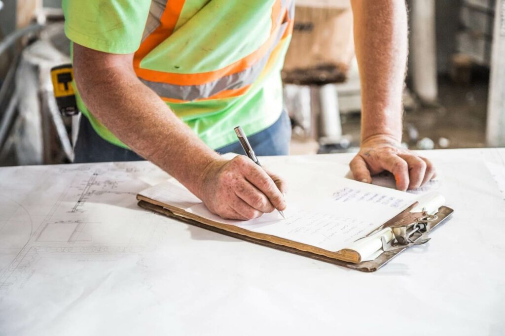 An man writing construction marketing ideas on a checklist