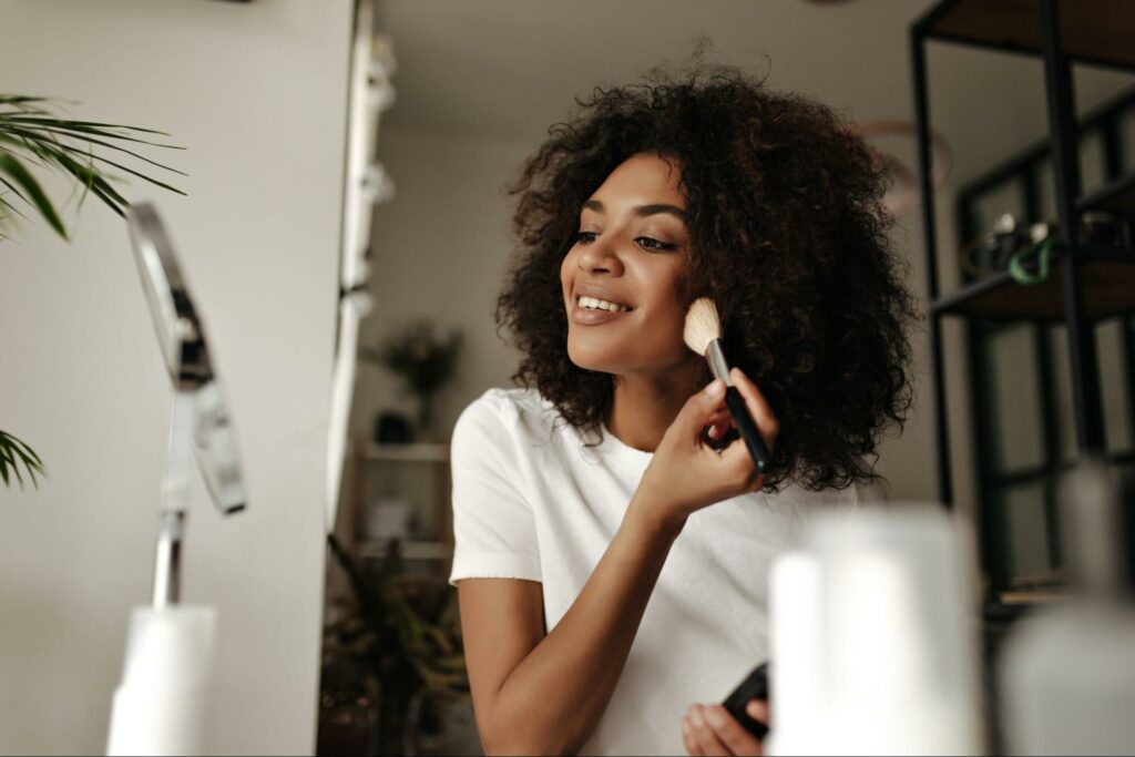 A woman applies makeup purchased from a beauty brand’s marketing campaign