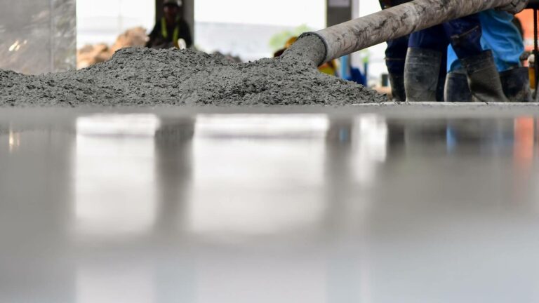 A shiny floor with wet concrete poured onto it.
